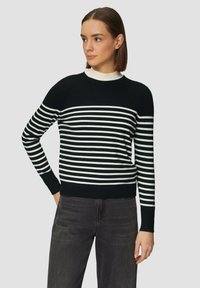 Schwarz-weiß gestreifter Pullover mit rundem Halsausschnitt und langen Ärmeln, ausgestattet mit einem gerippten Halsausschnitt und Bündchen, auf einem neutralen Hintergrund präsentiert.