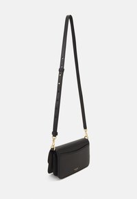Black leather crossbody bag with a structured design. Features a gold-tone clasp and adjustable strap. Smooth texture and minimal detailing.