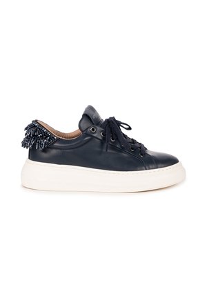 Czarny skórzany sneaker z białą grubą podeszwą, czarnymi sznurówkami i ozdobnymi czarnymi koralikami na kołnierzu pięty.