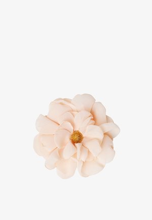 Weiche Pfirsich-Stoffblume mit geschichteten Blütenblättern und einem detaillierten goldenen Zentrum vor weißem Hintergrund.