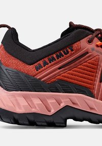 Chaussures de randonnée rouges et noires avec une tige texturée, une semelle intermédiaire renforcée et un motif de semelle distinctive en caoutchouc pour une bonne adhérence.