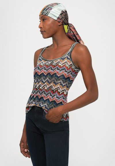 Multicolored tank top with a zigzag pattern in red, blue, and cream, featuring a scoop neckline and a slightly flared hem.