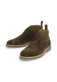 Bottines en suede vert foncé avec un design à lacets, finition texturée et semelle en caoutchouc. Présentent des coutures contrastantes de couleur claire et des languettes de tirage.