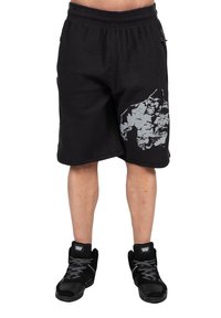 Zwarte gestructureerde sportshorts met een grafisch patroon aan de rechterkant. Gecombineerd met zwarte hoge sneakers met witte accenten.