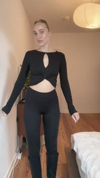 Svart langermet crop topp med et nøkkelhulls åpning og vridd frontdesign, paired med høytlivs svarte leggings. Glatt, elastisk stoff.