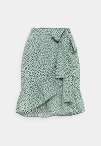 Falda verde menta con un patrón de lunares, dobladillo con volante y un lazo en la cintura. Hecha de una tela ligera para un diseño fluido.
