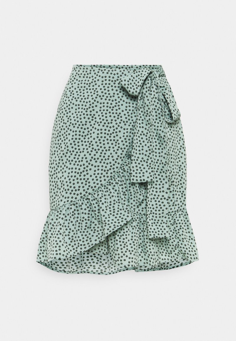 Falda verde menta con un patrón de lunares, dobladillo con volante y un lazo en la cintura. Hecha de una tela ligera para un diseño fluido.