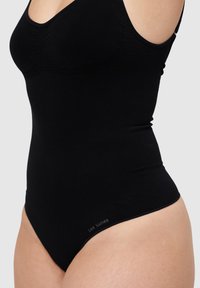 Černý body z hladké látky, s přiléhavým střihem, nastavitelnými ramínky a decentním logem po straně.