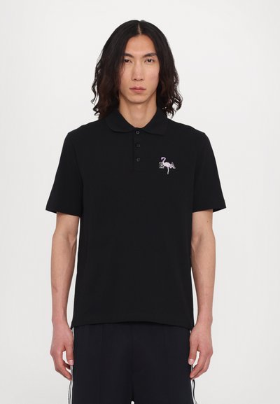 Black polo shirt made of cotton, featuring a collar, three-button placket, and an embroidered flamingo logo on the chest. Crew neckline.