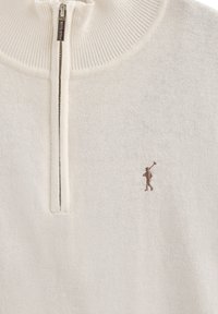 Cremefarbenem gestricktem Pullover mit einem Viertelreißverschluss und kleinem gesticktem Polo-Spieler-Logo auf der Brust.