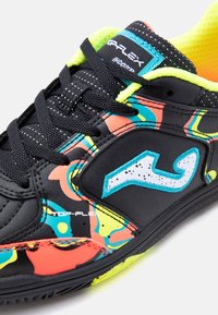 Μαύρο αθλητικό παπούτσι με νέον κίτρινη επένδυση, πολύχρωμα αφηρημένα σχέδια, μαύρα κορδόνια και λευκό λογότυπο στο πλάι.