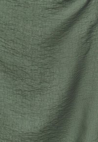 Tissu vert olive texturé avec un motif discret de tissage vertical et horizontal et de légers plis à la surface.