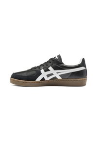 Black and white athletic shoe featuring a leather and suede upper, perforations for breathability, with a rubber sole and stitching accents.