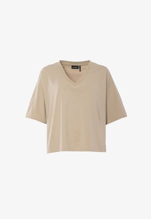 Camiseta oversize beige de manga corta con cuello en V y ajuste holgado, con etiqueta visible en el cuello, mostrada sobre fondo blanco.