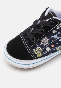 Czarny zamszowy sneakers z nadrukowanym na kanwie motywem galaktyki, z grafikami jaszczurki i astronauty, szytą białą podeszwą i czarnymi sznurówkami.