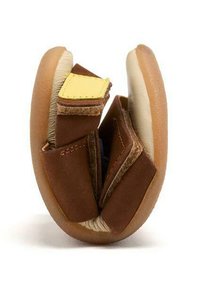 Scarpa in pelle marrone con suola morbida, design pieghevole e cinturino giallo a contrasto. L'interno è rivestito con una foderatura di colore chiaro.