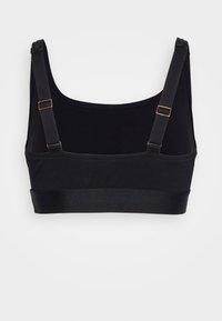 Bralette preta com alças ajustáveis e uma cintura lisa, apresentando um design simples e uma textura de tecido suave e elástica.