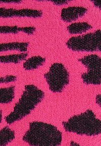 Mönstrad tyg med djärva rosa och svarta leopardprickar. Texturerad yta med en mjuk, fluffig finish. Hög kontrast mellan färger och distinkta former.