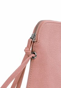Růžová kožená kabelka s texturovaným povrchem, vybavená stříbrným zipem, páskem a kovovým detailem na boku.