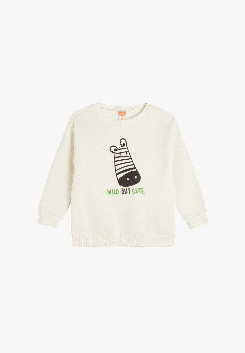 Sudadera de color crema con mangas largas, que presenta un gráfico de cebra negra y texto verde que dice "SALVAJE PERO LINDA" en la parte frontal.