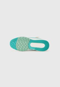 Semelle de basket blanche et teal avec un profil texturé, incluant des motifs de grip en forme d'étoile et rayés, isolée sur fond blanc.