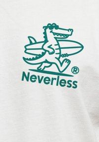 White fabric featuring a green cartoon crocodile holding a surfboard, with "Neverless" text underneath in matching green font.