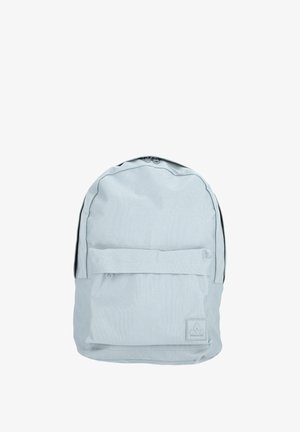 Sac à dos gris clair en tissu, de forme arrondie, avec une poche avant à rabat et un patch de logo en bas. Fermeture zippée sur le dessus.