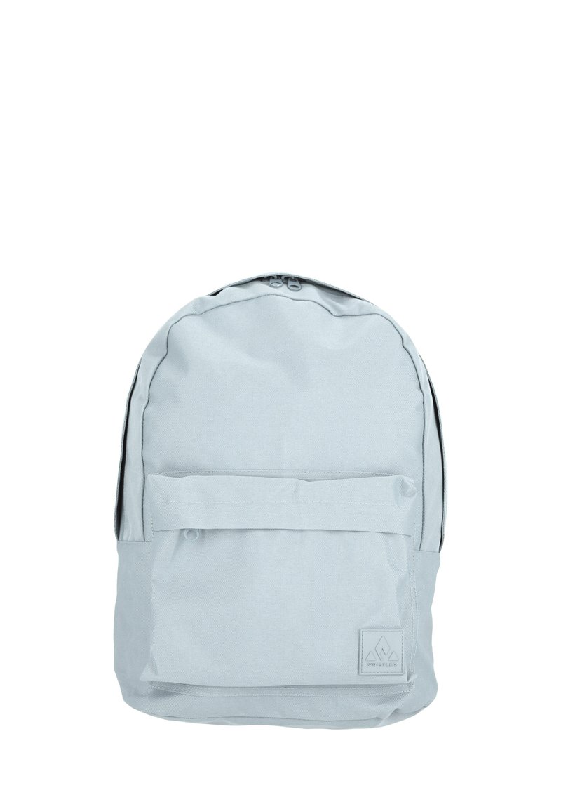 Sac à dos gris clair en tissu, de forme arrondie, avec une poche avant à rabat et un patch de logo en bas. Fermeture zippée sur le dessus.