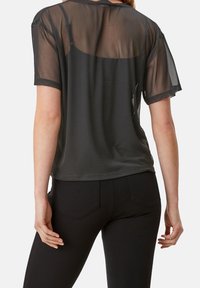 Sort gennemsigtig T-shirt med korte ærmer, afslappet pasform og scoop rygdesign, lavet af letvægts, gennemskinneligt stof.