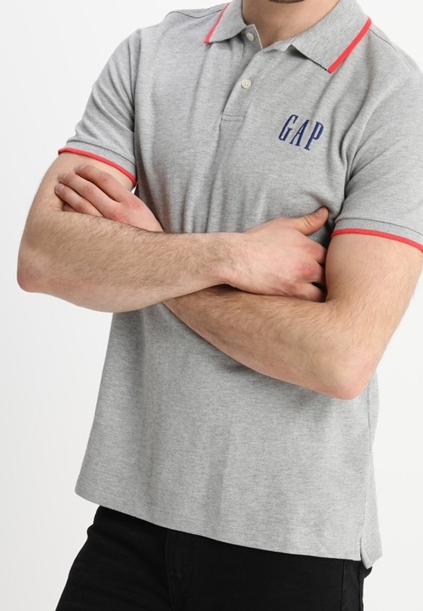 Polo gris avec des accents rouges sur le col et les manches, arborant un logo "GAP" bleu marine sur la poitrine. Fabriqué en tissu en coton mélangé texturé.