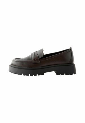 Bruine leren loafers met een stevige zwarte rubberen zool, voorzien van een ronde neus en een decoratieve band over de bovenkant.