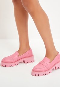 Roze instappers met een chunky gezaagde zool. Gemaakt van glad leder, met decoratieve stiksels en een subtiele verhoogde band over de wreef.