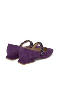 Scarpe in suede viola con tacco basso a blocco, caratterizzate da una fascia decorativa adornata con falsi gemme scure e una punta affilata.