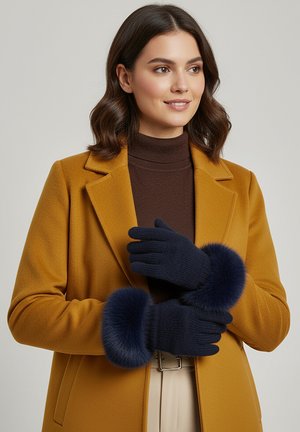 Navy gloves with a ribbed texture and plush fur cuffs, worn by a person in a mustard coat over a brown sweater.