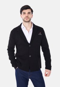 Cardigan nero a maglia con rever a punta, chiusura con un bottone e due tasche frontali. Presenta un fazzoletto da taschino con motivo.