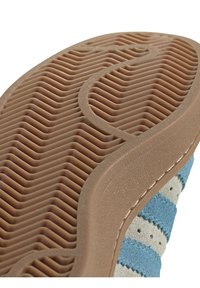 Wildledersneaker mit einer strukturierten braunen Gummisohle. Verfügt über graue und hellblaue Streifen an der Seite sowie feine Nähdetails.