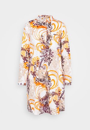 Robe chemise blanche à manches longues avec des motifs floraux abstraits vibrants en orange, beige et violet, ornée d'un col et d'une fermeture boutonnée sur le devant.
