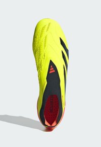 Crampon de football jaune avec un dessus texturé, des accents noirs et un intérieur rouge. Présente un design de chaussette ajustée et une semelle extérieure texturée.