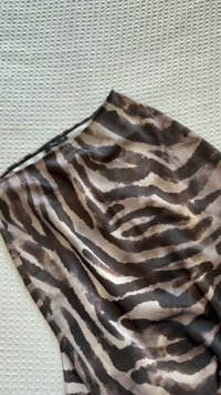 Blouse marron et beige avec un motif rayé tigre, en tissu lisse, avec une coupe décontractée et un col rond.