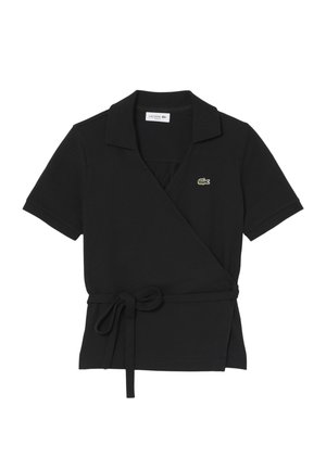 Polo nera a maniche corte con scollo a incrocio, cintura laterale annodata e piccolo logo di coccodrillo verde sul petto.