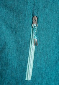 Tealfärgad tyg med dragkedja, en kontrasterande mintgrön dragkedja och en texturerad yta. Metalldragkedja med två draghandtag.