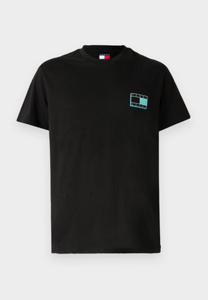 Crna pamučna majica s kratkim rukavima. Ima tirkizni pravokutni logo s natpisom "TOMMY JEANS" na lijevoj strani grudi.