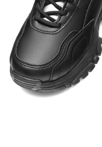 Musthave musta spordijalats, millel on nahk ülemine osa, tekstureeritud aktsendid, tõstetud kummitald ja reguleeritavad paelad. Ümar varvas koos õmblustega detailidega.