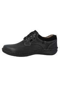 Scarpa in pelle nera con punta arrotondata, design con lacci, cuciture a contrasto e colletto morbido. Presenta un'esterno testurizzato e una suola imbottita.