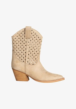 Botas de cowboy de ante beige con diseño superior trenzado, punta inclinada y tacón de madera apilada. Incluye un lazo para facilitar el calzado.