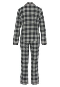 Black and white plaid pajama set, featuring a collared button-up top and matching pants with straight legs and hemmed cuffs.