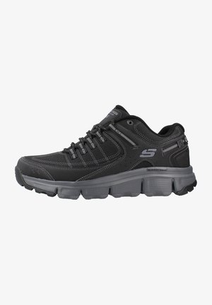 Baskets de sport noires avec une tige texturée, fermeture à lacets, col rembourré et semelle en caoutchouc épaisse. Présente des accents gris contrastants et un logo.