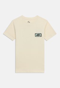 Μπεζ κοντομάνικο μπλουζάκι με μικρό ορθογώνιο μαύρο και γαλάζιο σχέδιο στο αριστερό στήθος που απεικονίζει ένα κύμα και ένα λογότυπο βουνού.