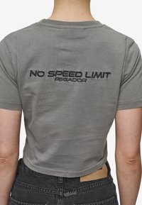 Grå kortermet t-skjorte med rund hals som har svart brodert tekst "NO SPEED LIMIT" og "PEGADOR" på ryggen. Myk stofftekstur.
