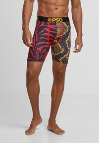 Boxeri ajustați pentru bărbați, cu un print viu de tigru roșu și negru pe o parte și un model de șarpe galben și negru pe cealaltă.